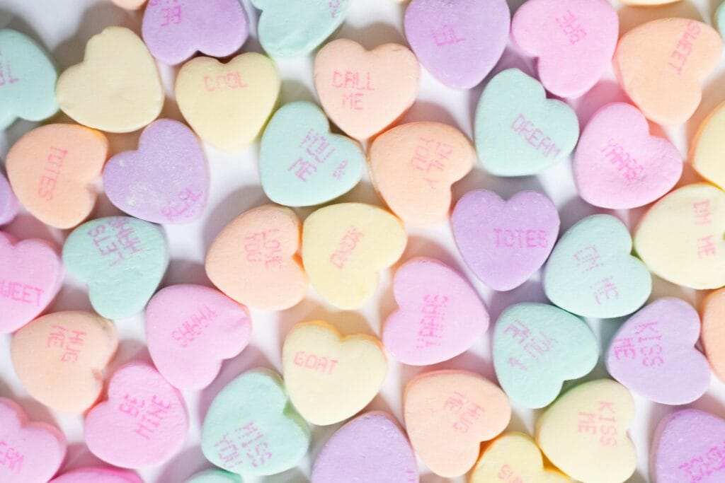 A pile of conversation hearts on a white surface