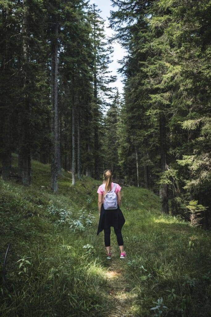 Woman carrying backpack on forest