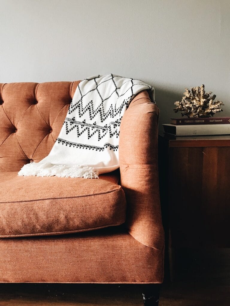 White and black textile on brown couch