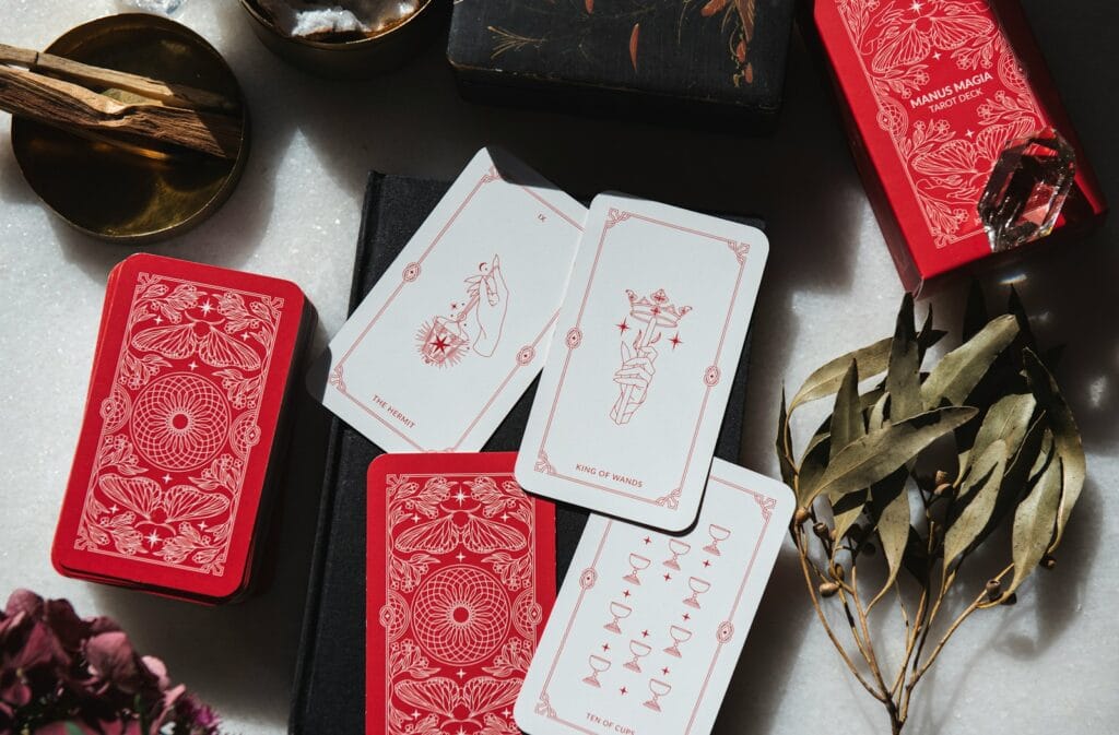 A table topped with lots of red and white tarot cards