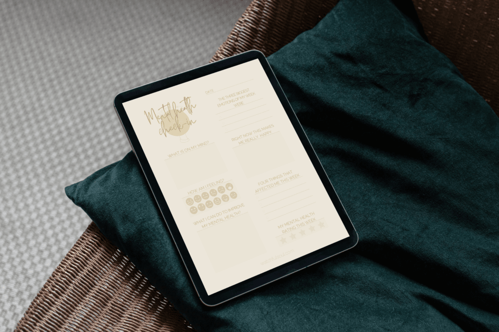 A tablet on a green cushion, showing the ‘mental health check-in’ journal with prompts for emotional well-being and stress tracking.